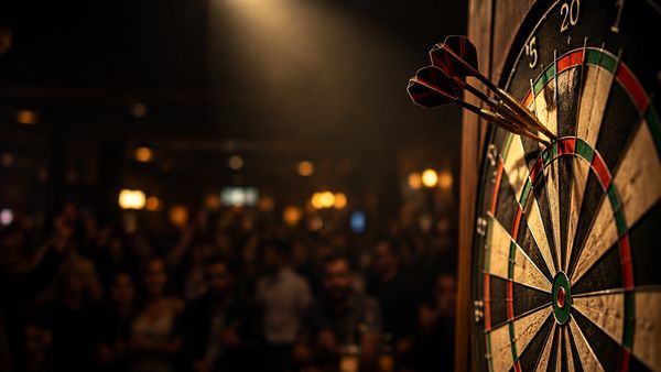 Tikkataulu pimeässä pubissa, kolme tikkaa triplakahdessakymmenessä, yksi lämmin kohdevalo, sumea yleisö taustalla, darts-vedonlyönti