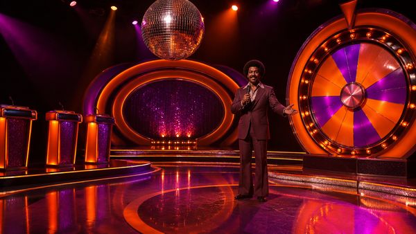 Retro 70-luvun disko game show -lavastus peilipallolla, neonrenkailla ja jättimäisellä kiiltävällä pyörällä, violetti ja oranssi valo. Funky Time